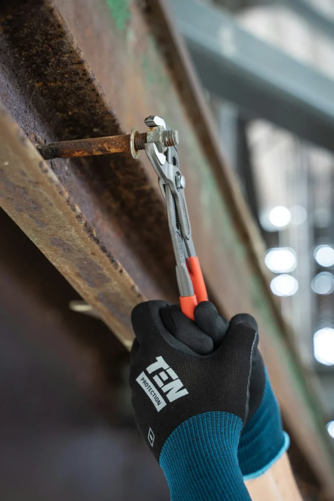 Klucz nastawny dokręcający śrubę na stalowej konstrukcji